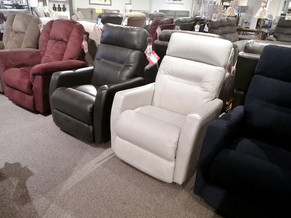 A display in the furniture store features four 787 Lennon Leather Rocker Recliners by La-z-boy, each showcasing a tailored look with oversized comfort and available in brown, black, white, and navy blue upholstery.