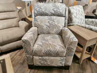 The 458 Rheeves Hi-Leg Recliner by La-z-boy, proudly made in America, showcases a fern pattern and stands elegantly on a wooden floor. Its decorative wood legs perfectly complement the surrounding furniture pieces.