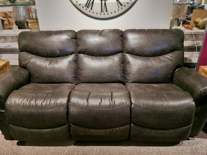 The 521 James Sofa by La-Z-Boy, a three-seater dark brown reclining sofa made in America, is showcased in a cozy living room setting with a large wall clock in the background.