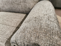 Close-up of an armrest on the La-Z-Boy 706 Jay Power Loveseat with head-rest, featuring transitional style highlighted by textured gray fabric with woven material detail and cushioned padding for personalized reclining comfort.