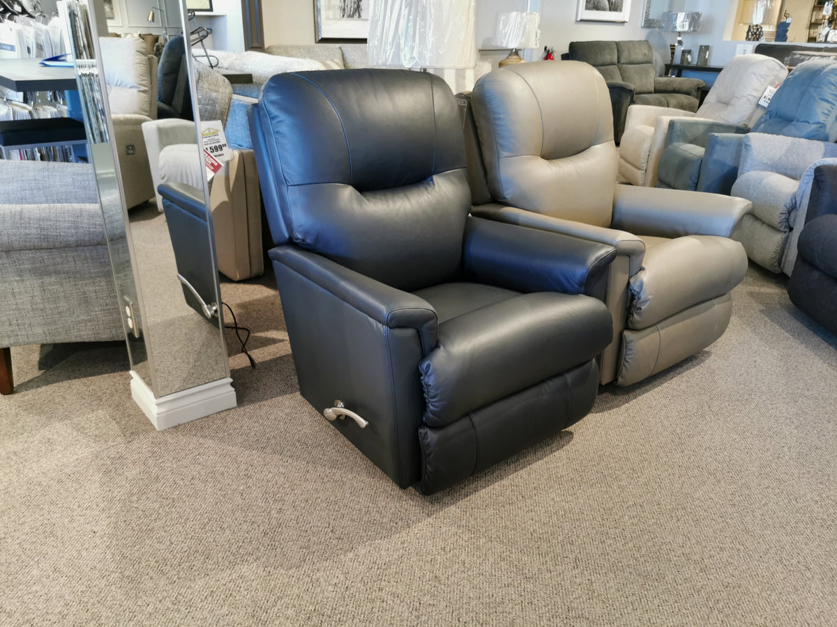 The showroom features a La-Z-Boy 783 Aries Rocker Recliner alongside a beige recliner, each offering comfort and durability. Additional stylish furniture pieces enhance the display in the background, perfectly blending aesthetics with functionality.