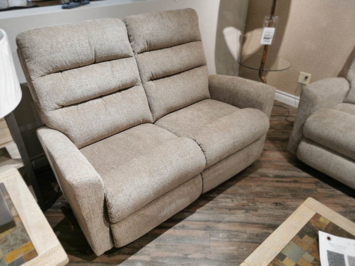 A La-z-boy 786 Liam Reclining Loveseat with adjustable leg-rests sits on a wooden floor in a furniture showroom.