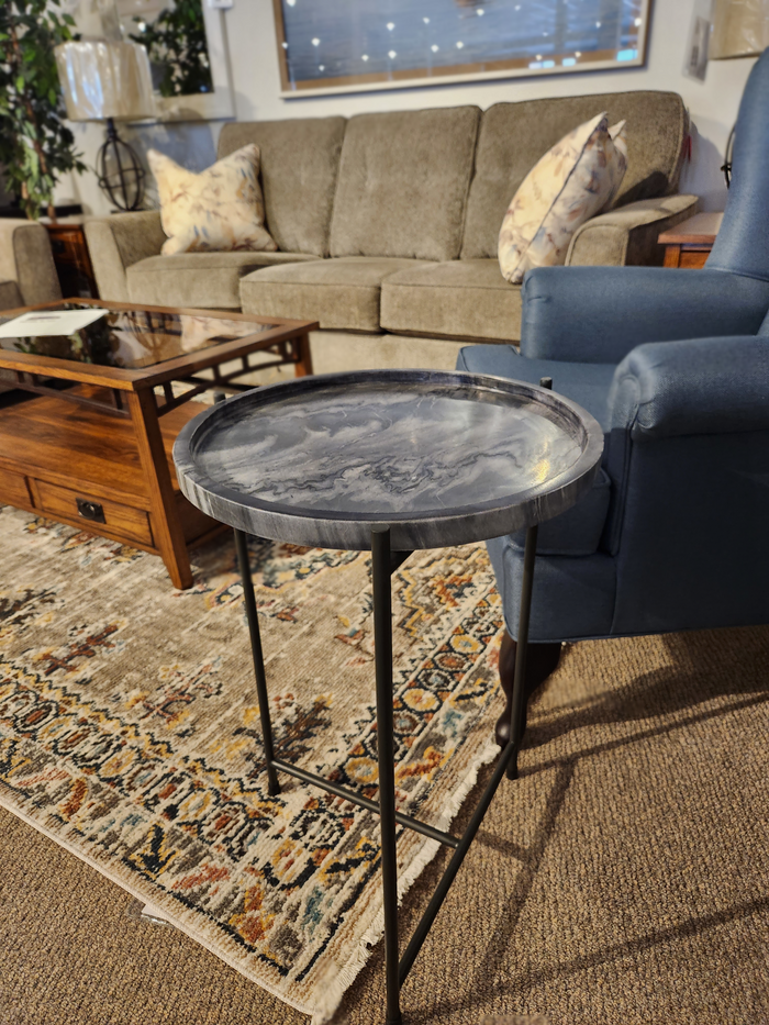 The Mercana 68959 Stella Accent Table complements the blue armchair on a patterned rug.