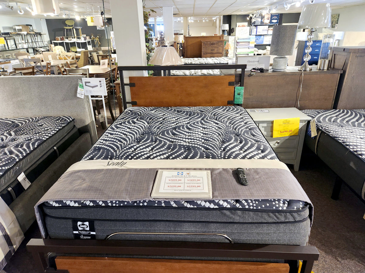 A furniture store showroom showcases three Sealy RMDH H2 Euro Top Medium Mattresses, each adorned with breathable fibers and intricate patterns, all illuminated under bright ceiling lights.