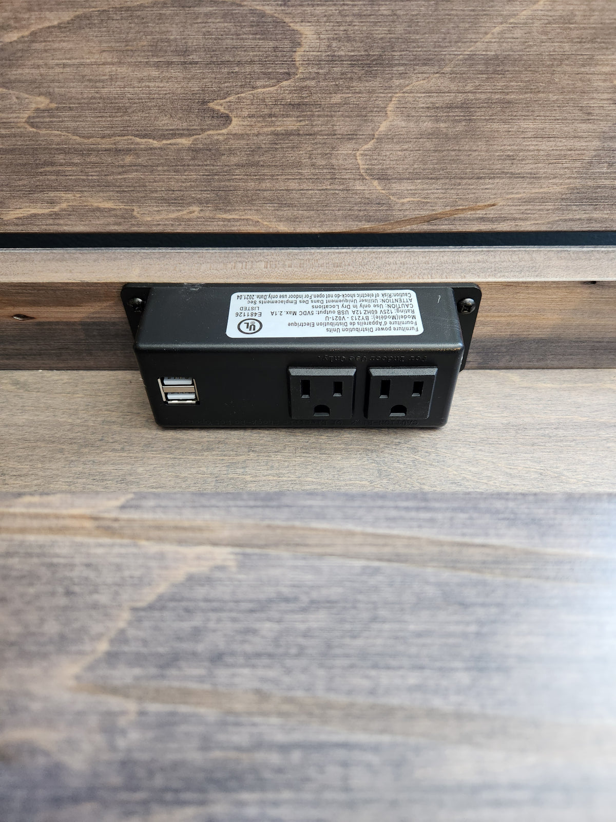 The Handstone Steel City 3 Drawer Night Stand features a charging station with standard sockets and USB ports on wood.