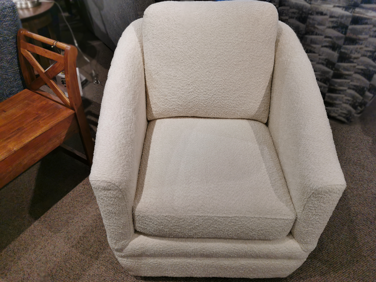 A plush Trendline 312 Swivel Chair with a square design sits on a carpeted floor, next to a wooden side table. This elegant piece measures LDH 32" x 36" x 36", promising both comfort and style in any living space.