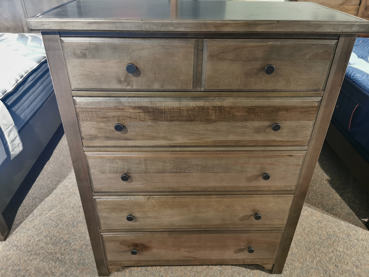 The Vaughan Bassett 801 Cool Farmhouse Chest features cherry veneers and custom pewter pulls, elegantly standing on a carpet.