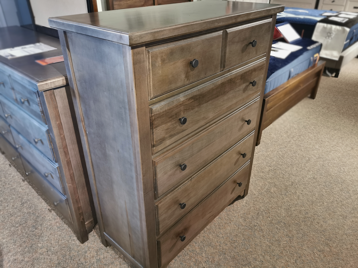 A Vaughan Bassett 801 Cool Farmhouse 5-Drawer Chest with cherry veneers and black knobs is on a carpeted floor.