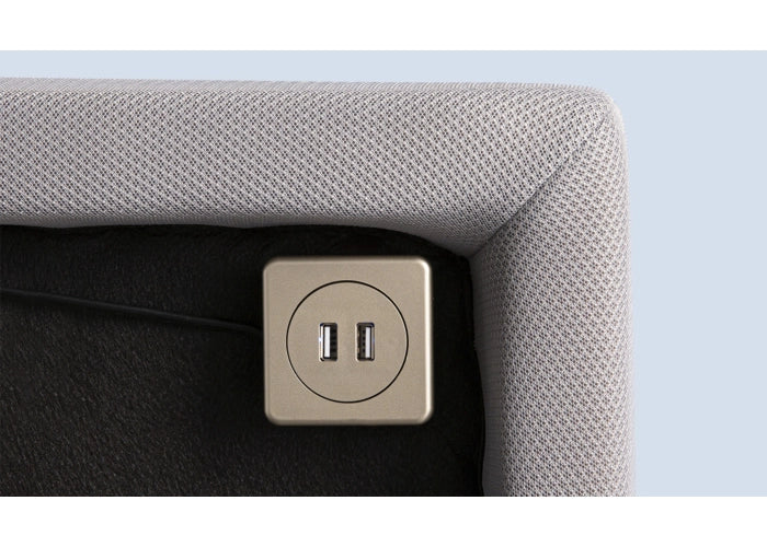 Beige fabric sofa armrest with USB ports and a connected black cable, featuring the Flex LS Queen Adjustable Base by Bed Gear.