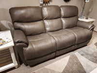 724 Trouper Leather Reclining Sofa by La-Z-Boy with sculpted seats, flanked by side tables on a beige carpet in showroom.