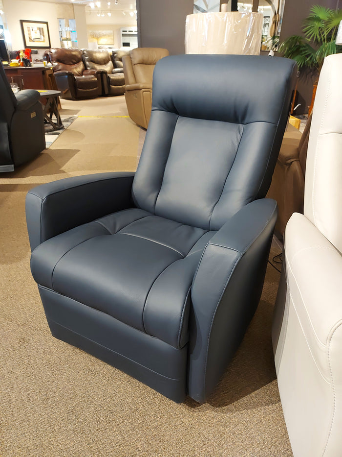 The 42210 Banff II Power Swivel Glider by Palliser, a dark blue leather recliner chair, is displayed in a furniture store showroom as part of an impressive recliner collection that guarantees ultimate comfort, surrounded by other chairs and bright lighting.