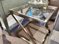 The Ashley Coylin Square End Table features a sleek metal base and glass top, perfect for decor next to your sofa.