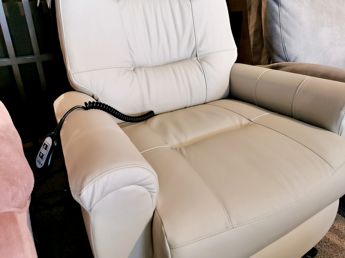 Introducing the Felicia Lift Chair by Best, a cream-colored leather recliner that adds a modern touch with its remote control conveniently placed on the left armrest. Its innovative Space Saver feature ensures this stylish design fits effortlessly into any room.