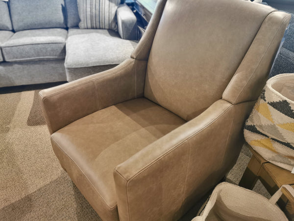 The Decor-rest 3053 Leather Power Recliner, in a sophisticated tan hue with a high back and exposed wood legs, sits gracefully on a carpeted floor, nestled beside a gray sofa and a woven basket.