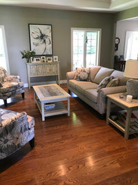 Living room with Superstyle 9613 Loveseat, floral armchairs, hardwood coffee table, side table, cabinet, wall art, and wood flooring.