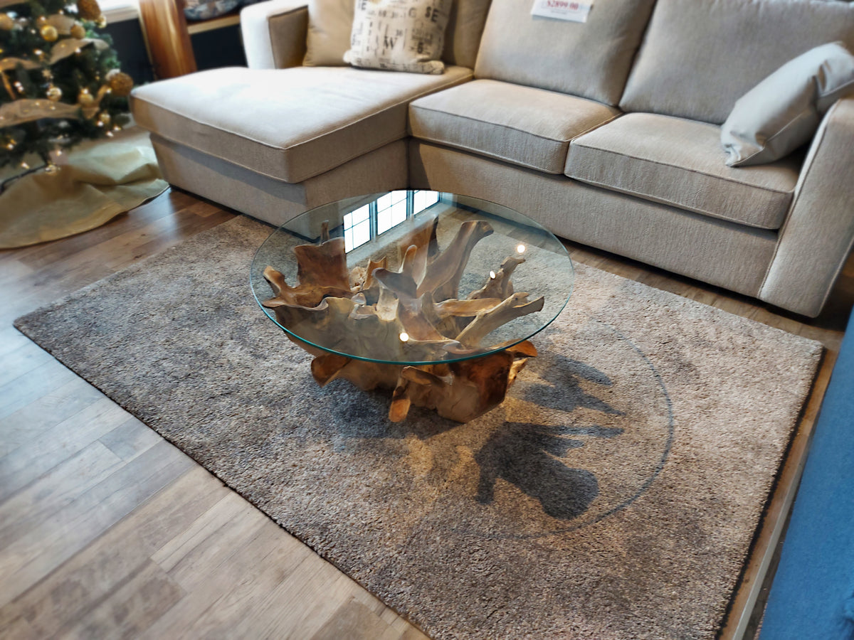 The Kalora Sable 8684/S718 coffee table with a wooden base sits on a modern rug before a beige sectional, with a Christmas tree nearby.