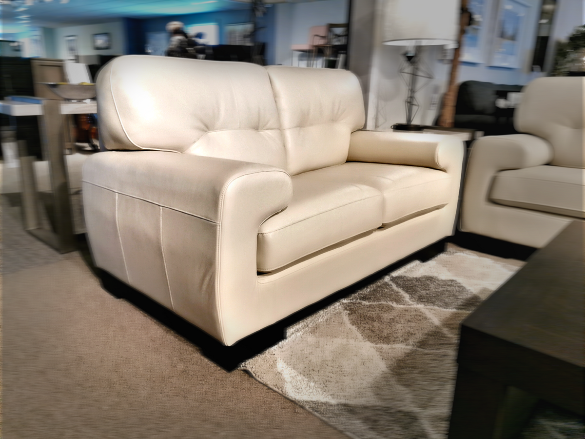 The showroom features the St. Lawrence Leather Loveseat by Leather Craft on a geometric patterned rug.