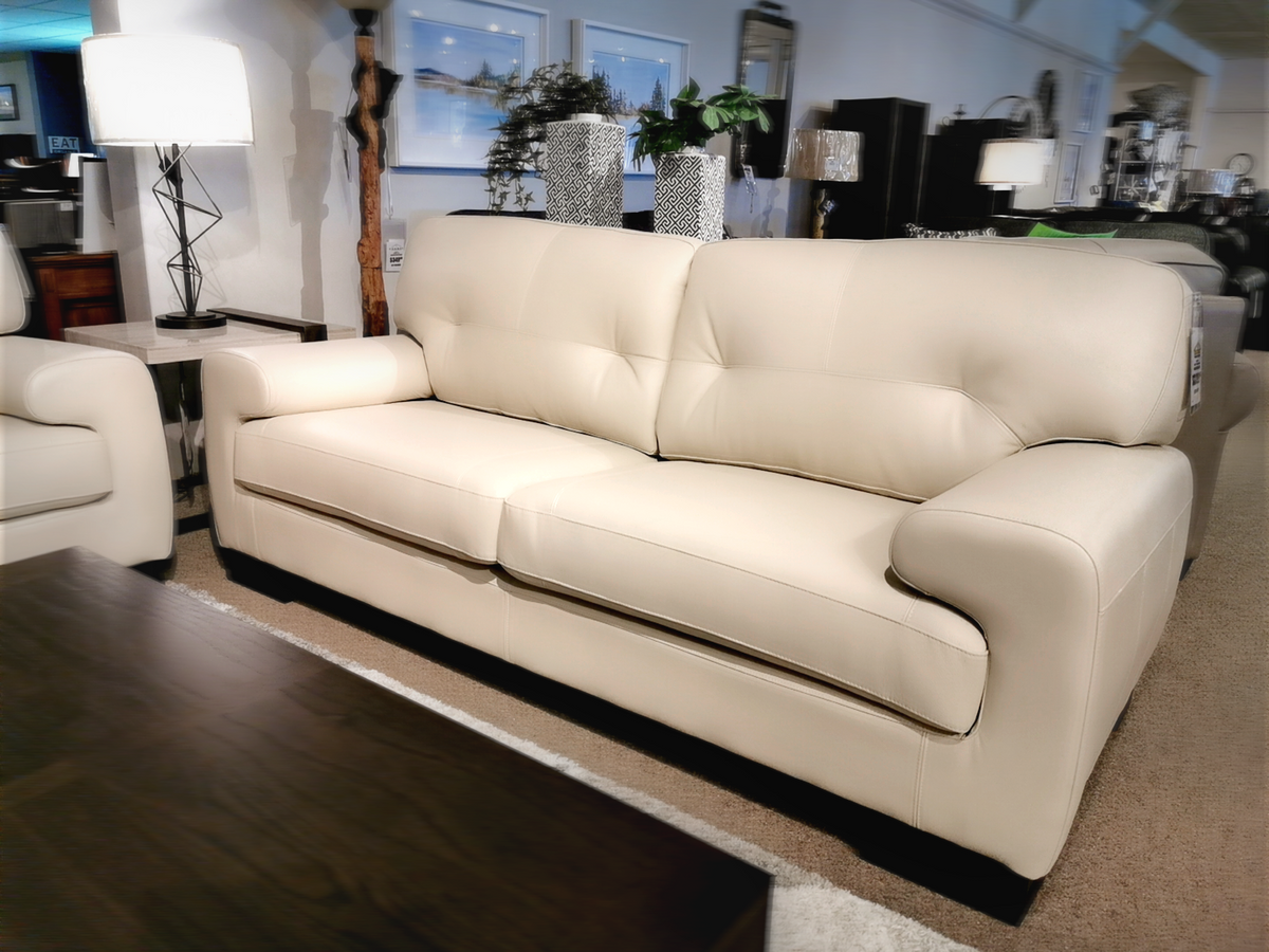 The living room showroom features the handmade St. Lawrence Leather Sofa by Leather Craft, surrounded by elegant decor.