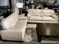 A showroom with St. Lawrence Leather Sofa, a Leather Craft dark wood coffee table, side table lamp, and a patterned rug.