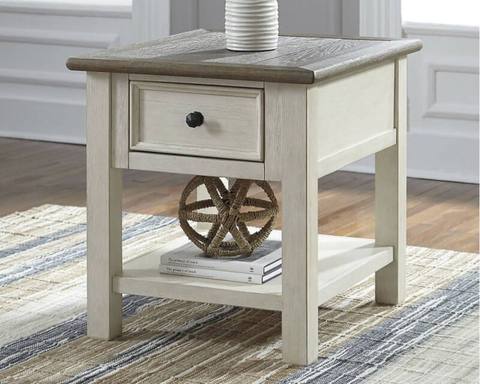 The Ashley Bolanburg End Table in antique white has a drawer and shelf, perfect for books and decor.