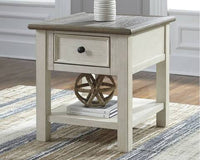 The Ashley Bolanburg End Table in antique white has a drawer and shelf, perfect for books and decor.