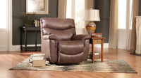 The 521 James Luxury Lift Chair from La-Z-Boy, upholstered in luxurious rich brown leather, sits gracefully on a cozy rug. It is complemented by a side table, lamp, and books while being bathed in natural light from the windows. This space-saving design enhances the living room with both style and functionality.