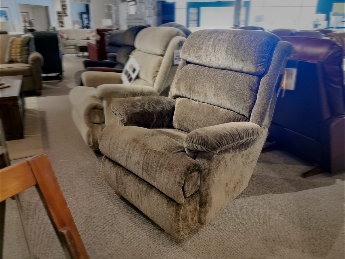 A row of plush La-Z-Boy 519 Astor Rocker Recliners is beautifully displayed in the furniture store, inviting customers to experience unparalleled comfort.