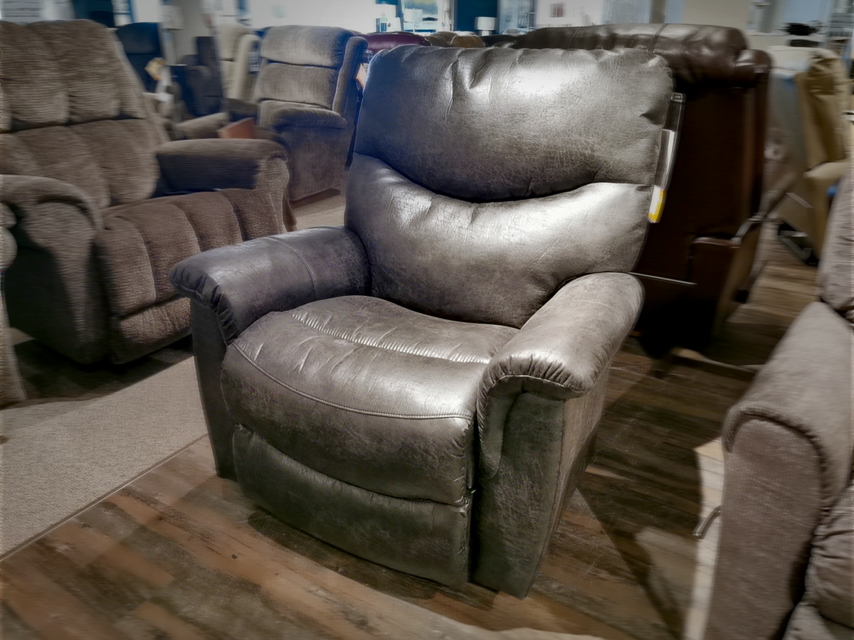 The La-Z-Boy 521 James Rocker Recliner, boasting a bucket style seat and advanced PowerReclineXR technology, is elegantly displayed on a wooden floor in this sophisticated furniture store setting.