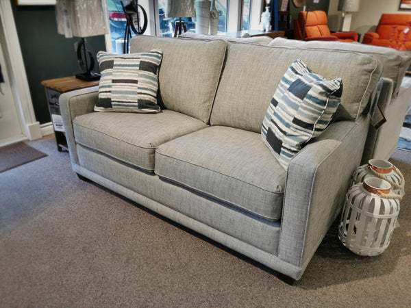 A La-z-boy 593 Kennedy Double Sofabed in light gray with striped pillows and customizable fabrics is on display.