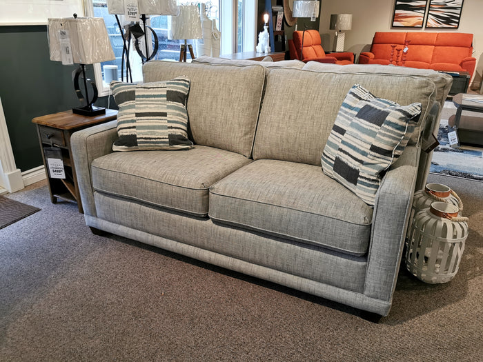 La-z-boy's 593 Kennedy Double Sofabed on display, next to a wooden side table and decorative basket.