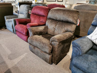 A row of upholstered reclining chairs, featuring the ultra-plush casual recliner and the La-z-boy 704 Reed Rocker Recliner, is displayed in a showroom, providing a continuous zone of comfort in a variety of colors.