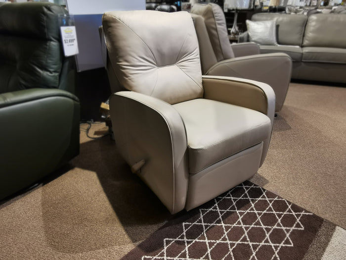 A 42002 Theo Wall-hugger Recliner by Palliser graces the carpeted showroom floor, surrounded by other chairs.