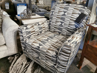 The Trendline 356 Chair with a geometric pattern is showcased in a store beside a beige chair and wooden side table.