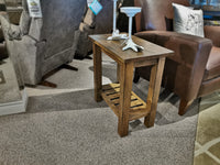 The NP101E Newport 14" End Table by Winners Only sits beside a brown leather armchair on a carpeted showroom floor.