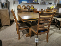 The furniture store is showcasing the Newport Dining Set by Winners Only, a solid hardwood dining set with six chairs that boasts transitional styling. The price tag is prominently placed on one of the table legs.