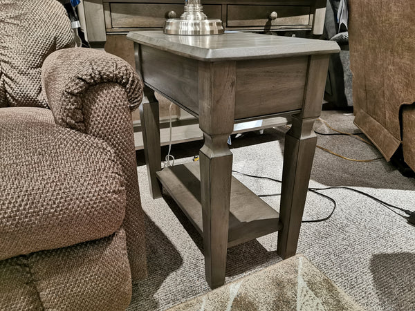 The Annapolis 14" Lamp Table by Winners Only stands beside a brown textured sofa in a carpeted room.