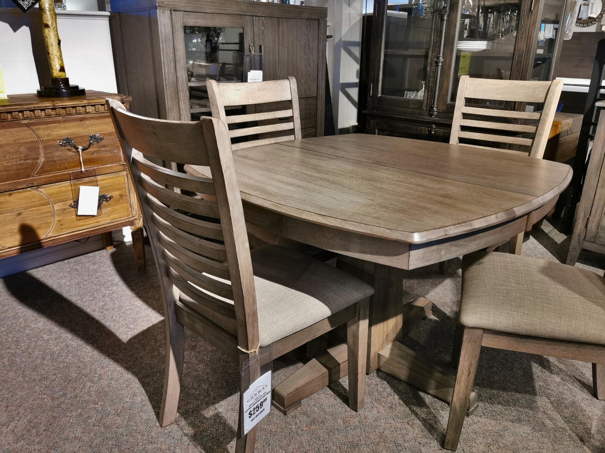 Ventura Dining Package by Winners Only, featuring a grey-washed wooden oval table and four matching chairs, displayed in a furniture store.