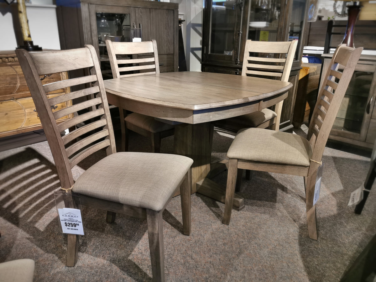 This elegant Ventura Dining Package from Winners Only features a grey washed finish, paired with six sturdy chairs on a plush carpeted floor in the furniture store. A price tag is prominently displayed on one chair, showcasing its value.